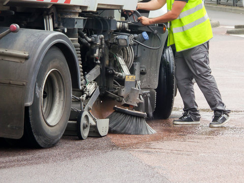 Worker with a truck cleaning a street