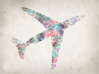 Silhouette of a plane created with passport stamps on textured background, travel concept