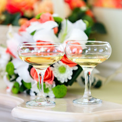Champagne in glasses on a background of a bouquet of flowers 