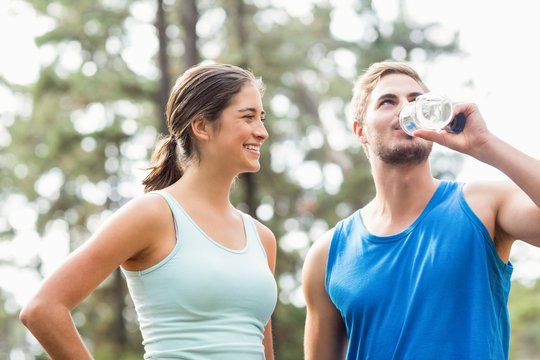 Happy joggers drinking water