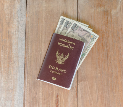 Japan money insert in Thai passport put on wooden floor