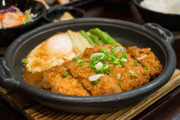 Cutlet pork simmered in miso sauce with fried egg on hot plate