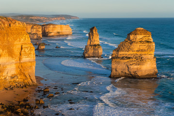 The yellow glow of the landmark Twelve Apostles along the famous Great Ocean Road, Victoria, Australia at sunset