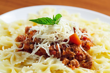 Pasta with meat cheese and garnish with mint.