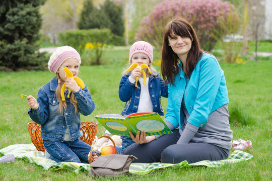 Two girls eating a banana on a picnic