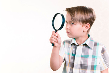 Boy looking through a magnifying glass