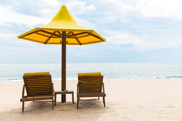 Beach chairs with umbrella and sand beach