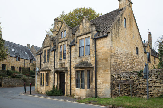 Street view of typical quaint stone house in English Cotswolds countryside