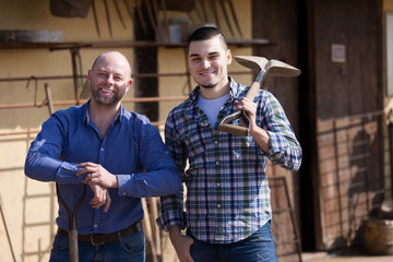 Two farmers standing with spades