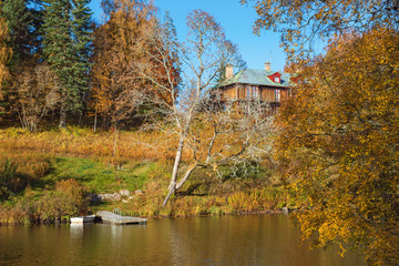 Country mansion on a hill by a lake and forest in autumn colors
