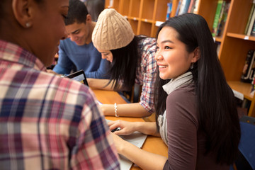 Friends in library socializing and studying together