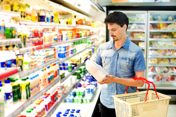 man buys milk at the supermarket