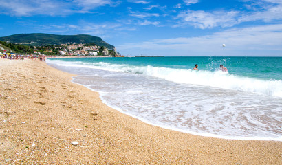 persone si divertono giocando a palla sulla spiaggia di Numana