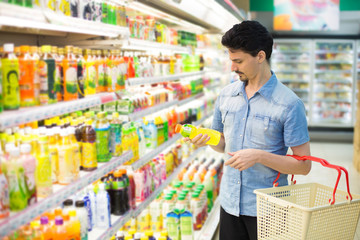 man in a supermarket buying a bottle of juice 