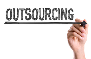 Hand with marker writing the word Outsourcing