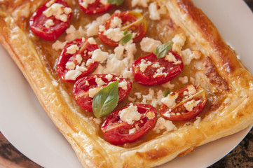 Tomato tart, puff pastry topped with mustard, cheese and cherry toamtoes.