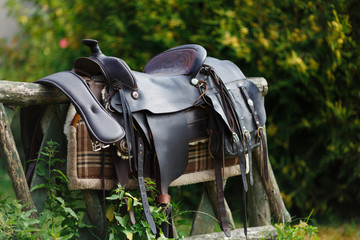 Old ornamental saddle on the wooden fence