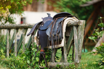 Old ornamental saddle on the wooden fence