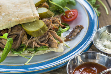Pulled lamb with fresh rocket salad and pitta bread