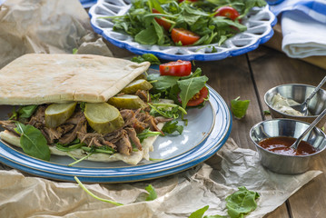 Pulled lamb with fresh rocket salad and pitta bread