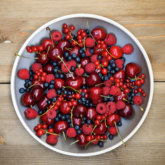  Fresh wild berries: raspberries, blueberries, currants and cherries. Top view 
