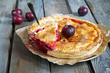 Plum cake on a rustic wooden table 