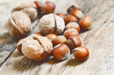 Hazelnuts and walnuts on an old wooden table, selective fokuks