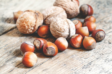 Hazelnuts and walnuts on an old wooden table, selective fokuks