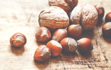 Hazelnuts and walnuts on an old wooden table, selective fokuks