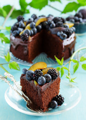 Chocolate cake with icing, blackberries and blueberries.
