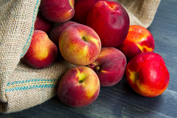 fresh peach on burlap sack on wood