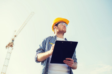 builder in hardhat with clipboard outdoors