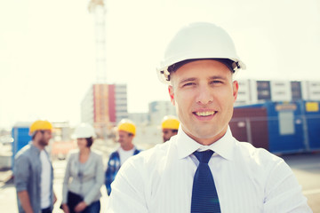 group of smiling builders in hardhats outdoors