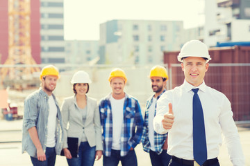group of smiling builders in hardhats outdoors