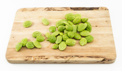 Parkia speciosa seed on wooden cutting board isolated on white background