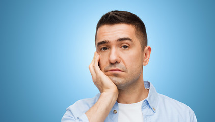 bored middle aged man face over blue background