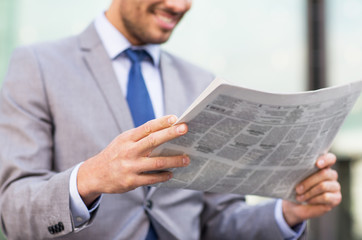 close up of smiling businessman reading newspaper