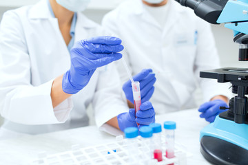 close up of scientists filling test tube in lab