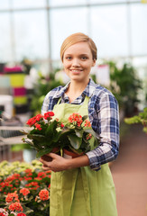 happy woman holding flowers in greenhouse