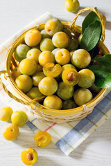 Berries yellow plums on a white wooden table