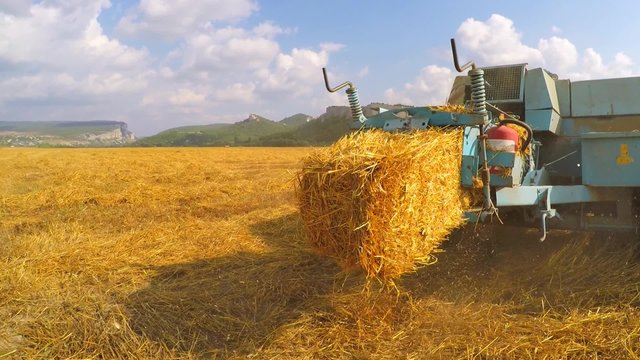 Tractor Baler Discharging Fresh Bale During Harvesting