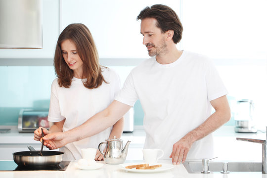 couple cooking breakfast