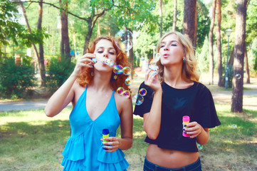 Fototapeta premium Two friends blowing soap bubbles