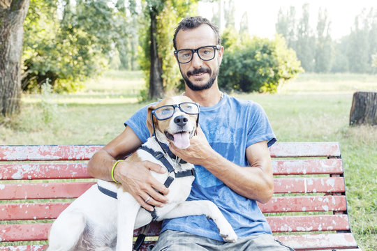 nearsighted man with his dog wearing glasses sitting on a bench