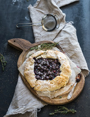 Homemade crusty pie or galette with blueberries, thyme and ice