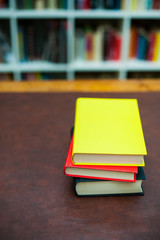 Pile of colored books on wooden desktop