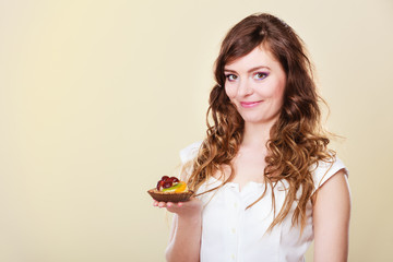 Smiling cute woman holds fruit cake in hand