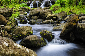 A tranquil steam forming unique patterns as it flows among the rocks.  