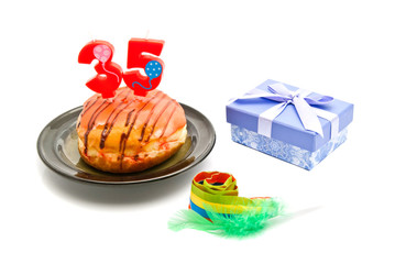donut with thirty five years birthday candle, whistle and gift o