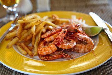 Shrimp and chips on the yellow plate, shallow focus